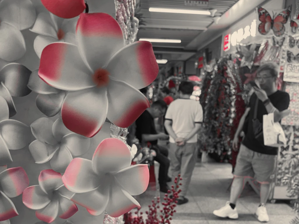 Yiwu- Un grupo de personas paradas frente a una exhibición de flores de papel.