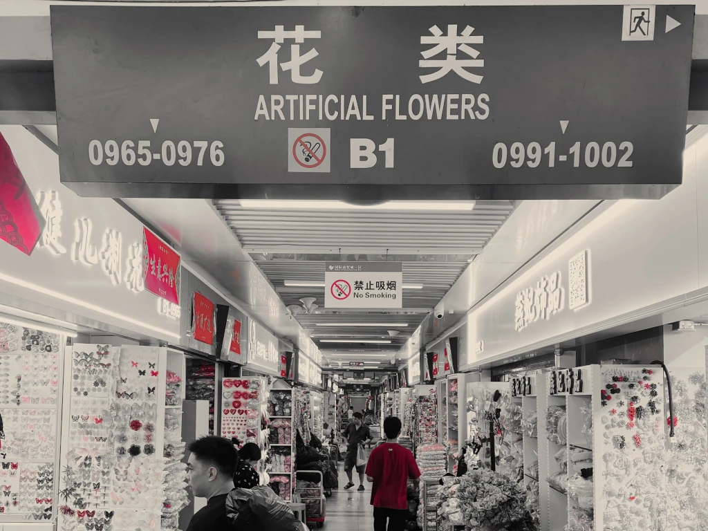 Yiwu- Una fotografía en blanco y negro de un centro comercial con un cartel que dice flores artificiales.