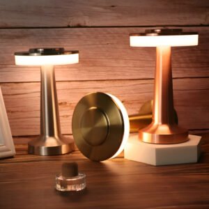 Hola Yiwu- Tres modernas Lámpara de mesa disco vintage USB - LP-1292TL lámparas con acabados metálicos, dos de pie y una tumbada, sobre una superficie de madera con una pequeña botella de cristal en el frente.